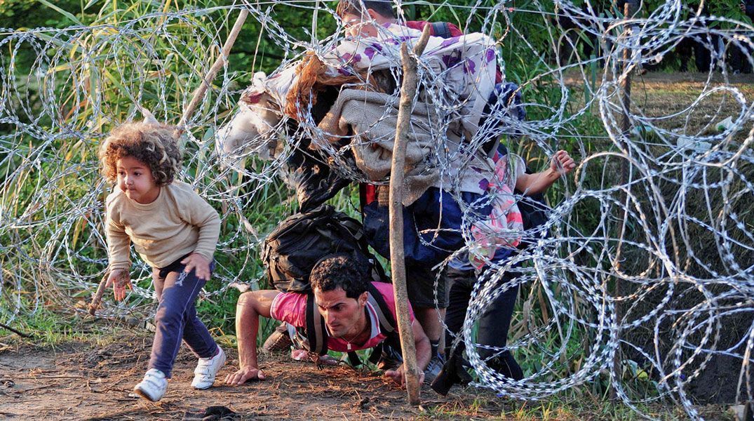 Familia trata de atravesar la valla fronteriza entre Hungría y Serbia. Foto: Csaba Segesvari